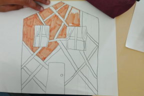 De retour en classe, un élève dessine une maison en colombage après l'avoir observée.