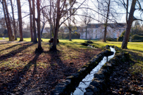 Vue vers le château du Grand Veneur. L’eau des sources rythme le parcours dans le parc.